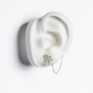 White ear mould shows iridescent unicorn earring with silver chain